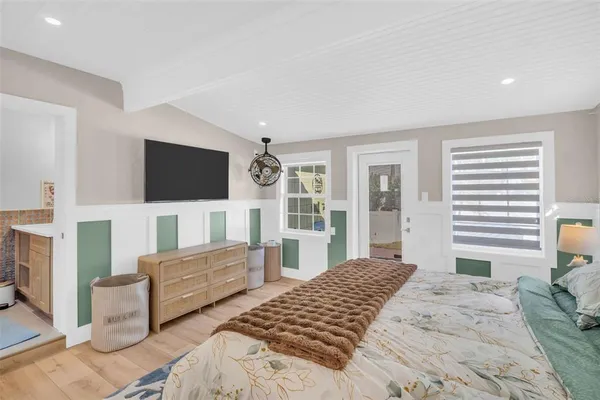 a bedroom with a bed and a flat screen tv