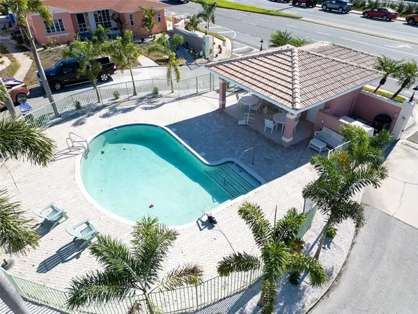 an aerial view of a swimming pool with outdoor seating