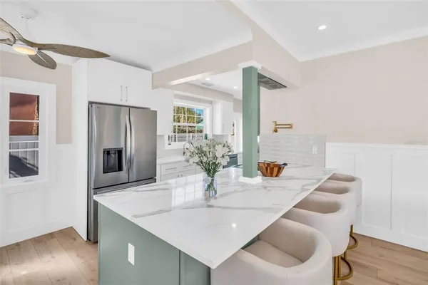 a kitchen with stainless steel appliances granite countertop a sink and a refrigerator