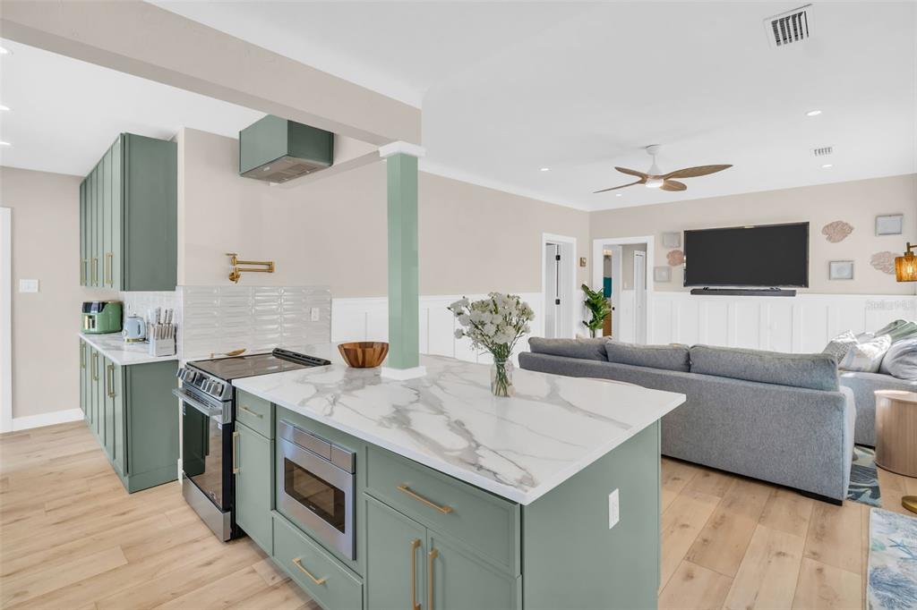 16613 Gulf Boulevard North Redington Beach, FL 33708 - Photo 9 of 51 a living room with stainless steel appliances granite countertop a kitchen island a stove and a sink