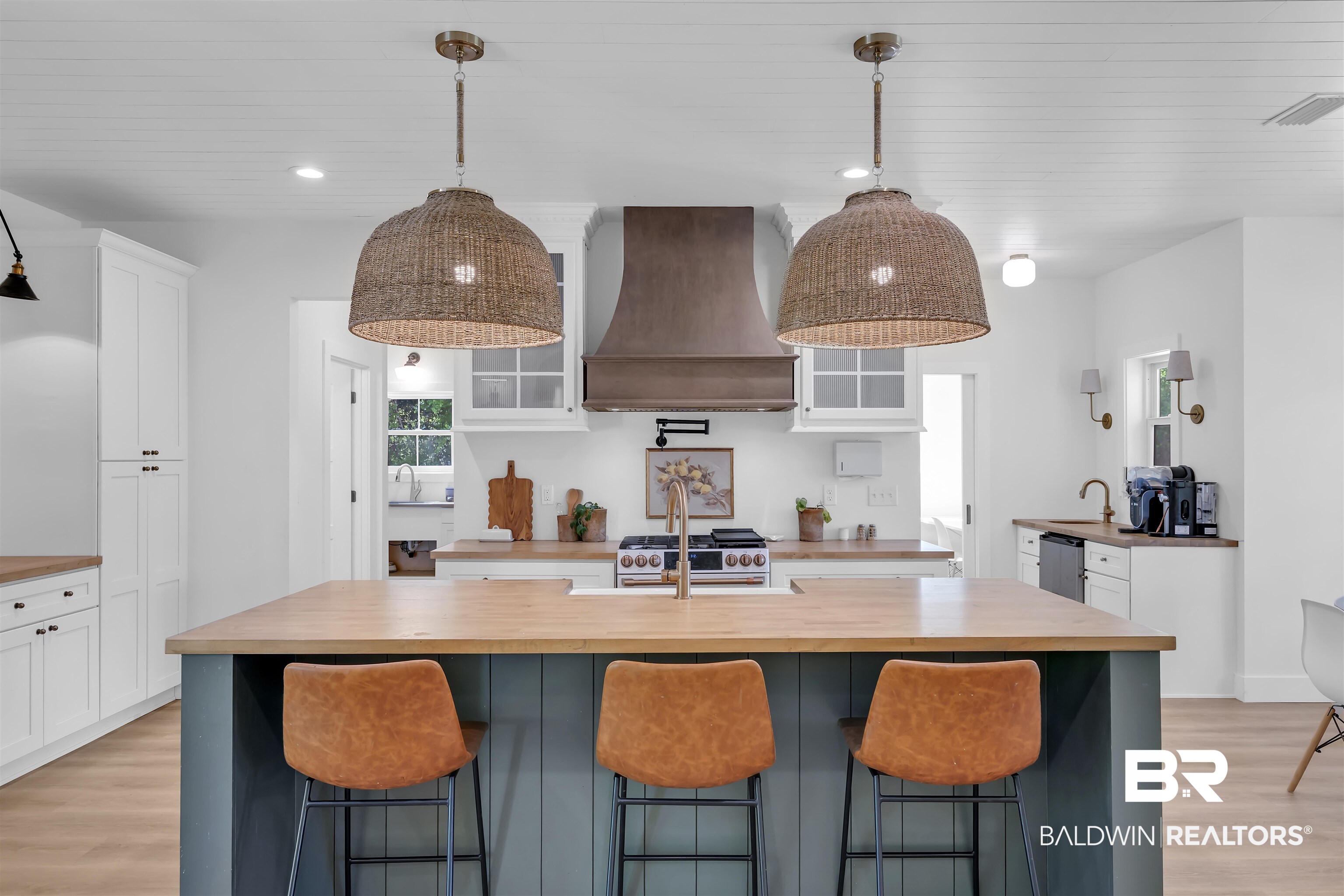 19058 James Road Gulf Shores, AL 36542 - Photo 11 of 49 Dual tone kitchen with light wood finished floors, wooden counters, a breakfast bar area, and two tone cabinets