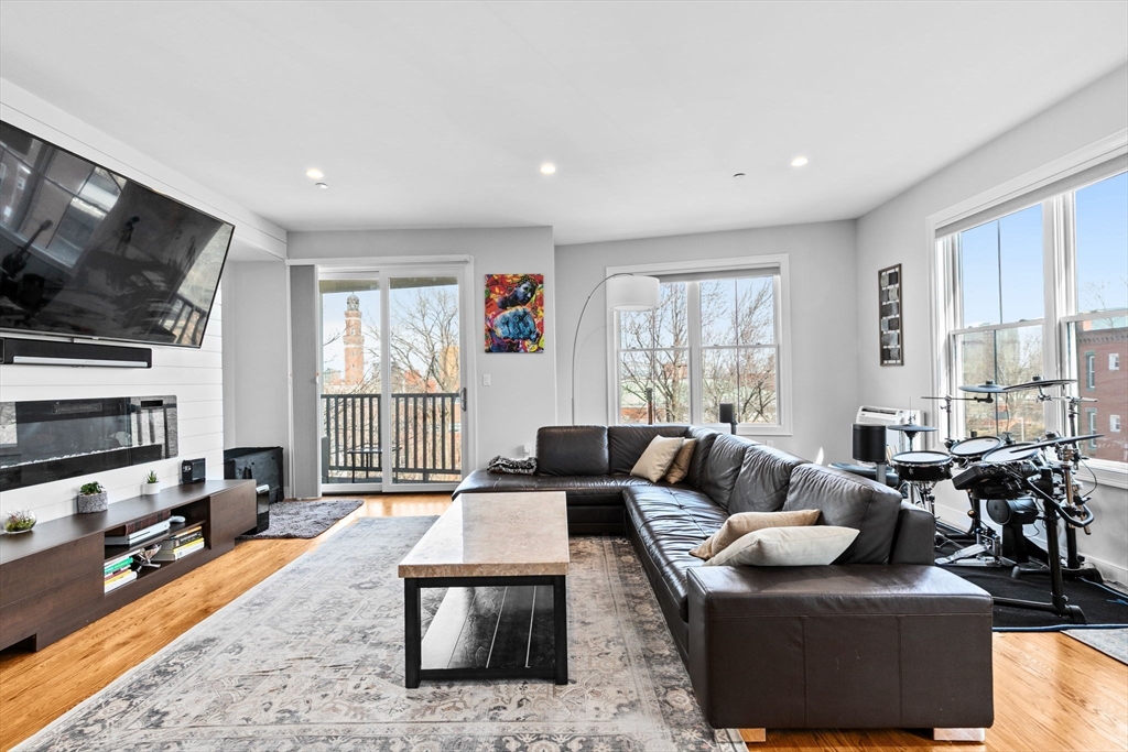 17 Centre Street, Unit 2 Boston, MA 02119 - Photo 11 of 34 a living room with fireplace furniture and a flat screen tv
