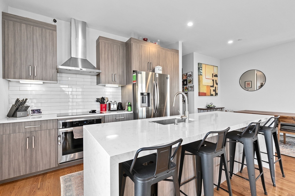 17 Centre Street, Unit 2 Boston, MA 02119 - Photo 2 of 34 a kitchen with a table chairs refrigerator and cabinets