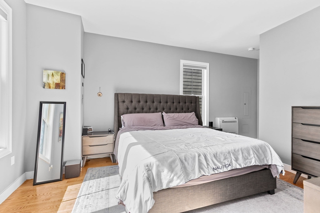 17 Centre Street, Unit 2 Boston, MA 02119 - Photo 23 of 34 a bedroom with a bed a painting and a lamp