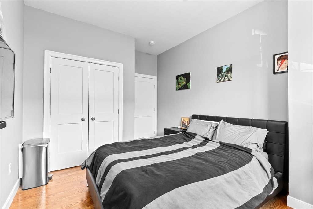 17 Centre Street, Unit 2 Boston, MA 02119 - Photo 25 of 34 a bedroom with a bed and painting on the wall