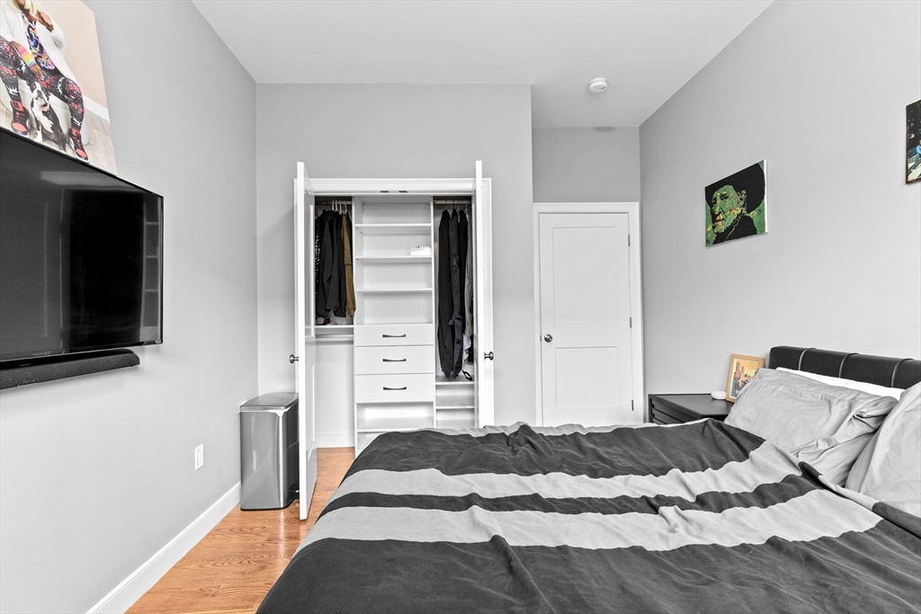 17 Centre Street, Unit 2 Boston, MA 02119 - Photo 26 of 34 a bedroom with a bed and a flat screen tv