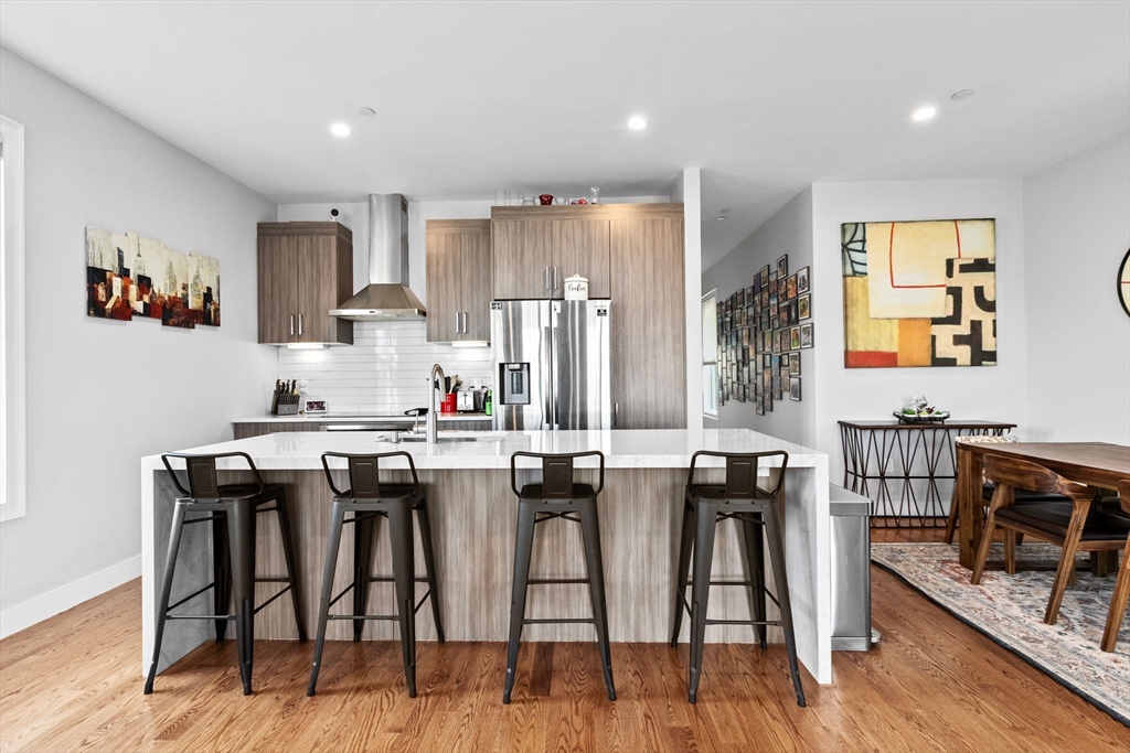 17 Centre Street, Unit 2 Boston, MA 02119 - Photo 3 of 34 a kitchen with stainless steel appliances granite countertop a table and chairs in it
