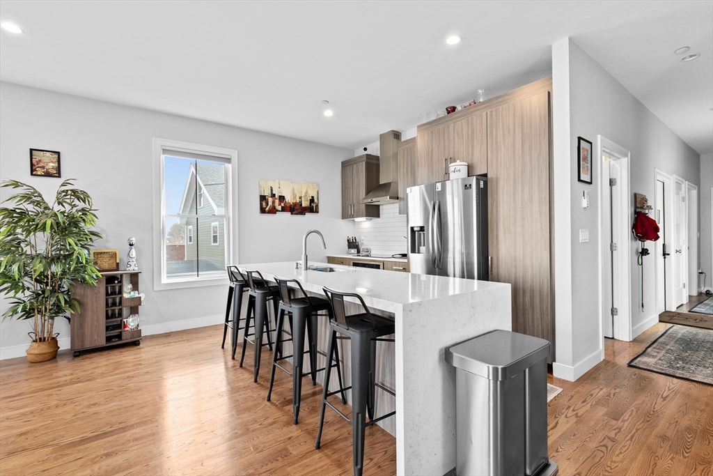17 Centre Street, Unit 2 Boston, MA 02119 - Photo 4 of 34 a kitchen with stainless steel appliances a dining table chairs and refrigerator