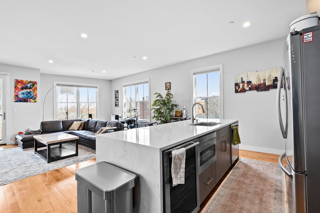 17 Centre Street, Unit 2 Boston, MA 02119 - Photo 5 of 34 a open kitchen with stainless steel appliances granite countertop a stove and a refrigerator