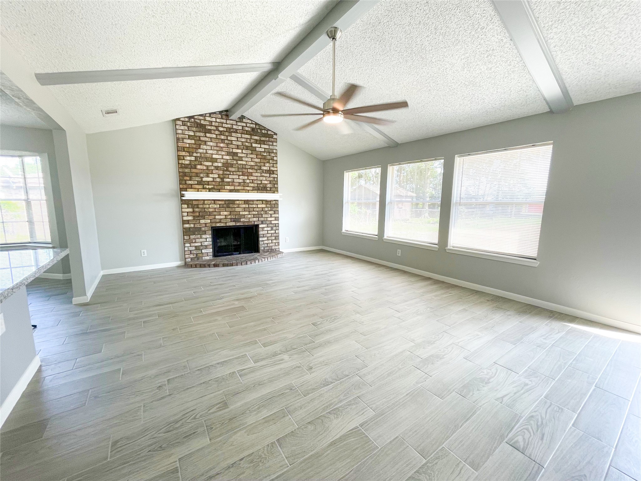 23460 Smith Road Porter, TX 77365 - Photo 14 of 46 an empty room with windows fireplace and windows