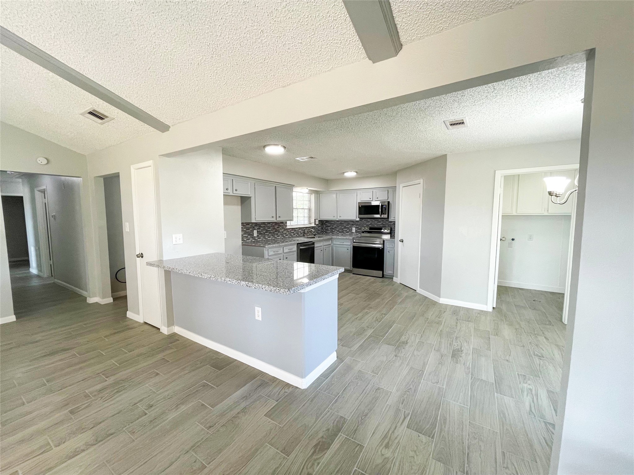 23460 Smith Road Porter, TX 77365 - Photo 15 of 46 a living room with stainless steel appliances kitchen island wooden floors and kitchen view