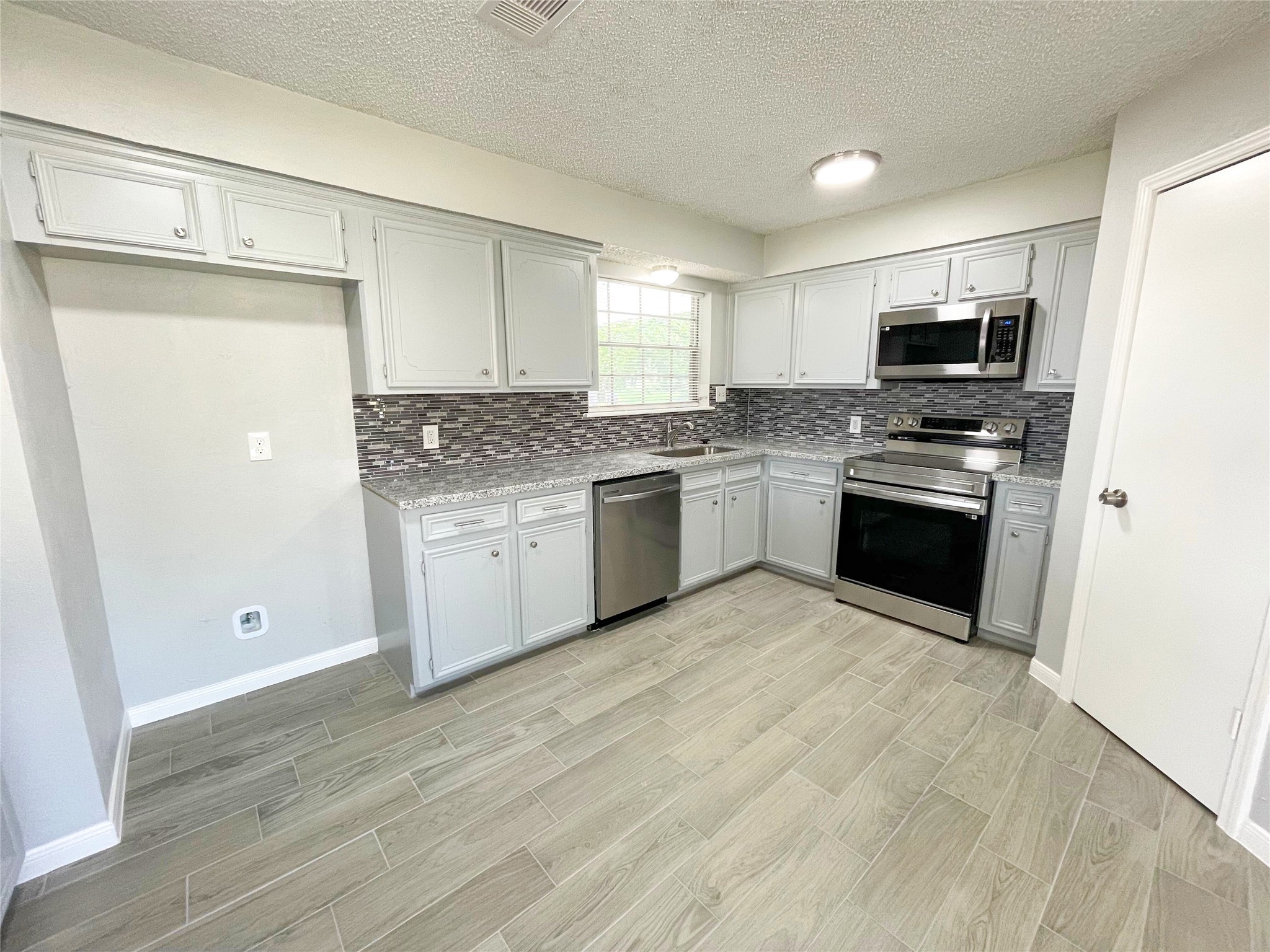 23460 Smith Road Porter, TX 77365 - Photo 17 of 46 a kitchen with stainless steel appliances granite countertop a stove and a refrigerator