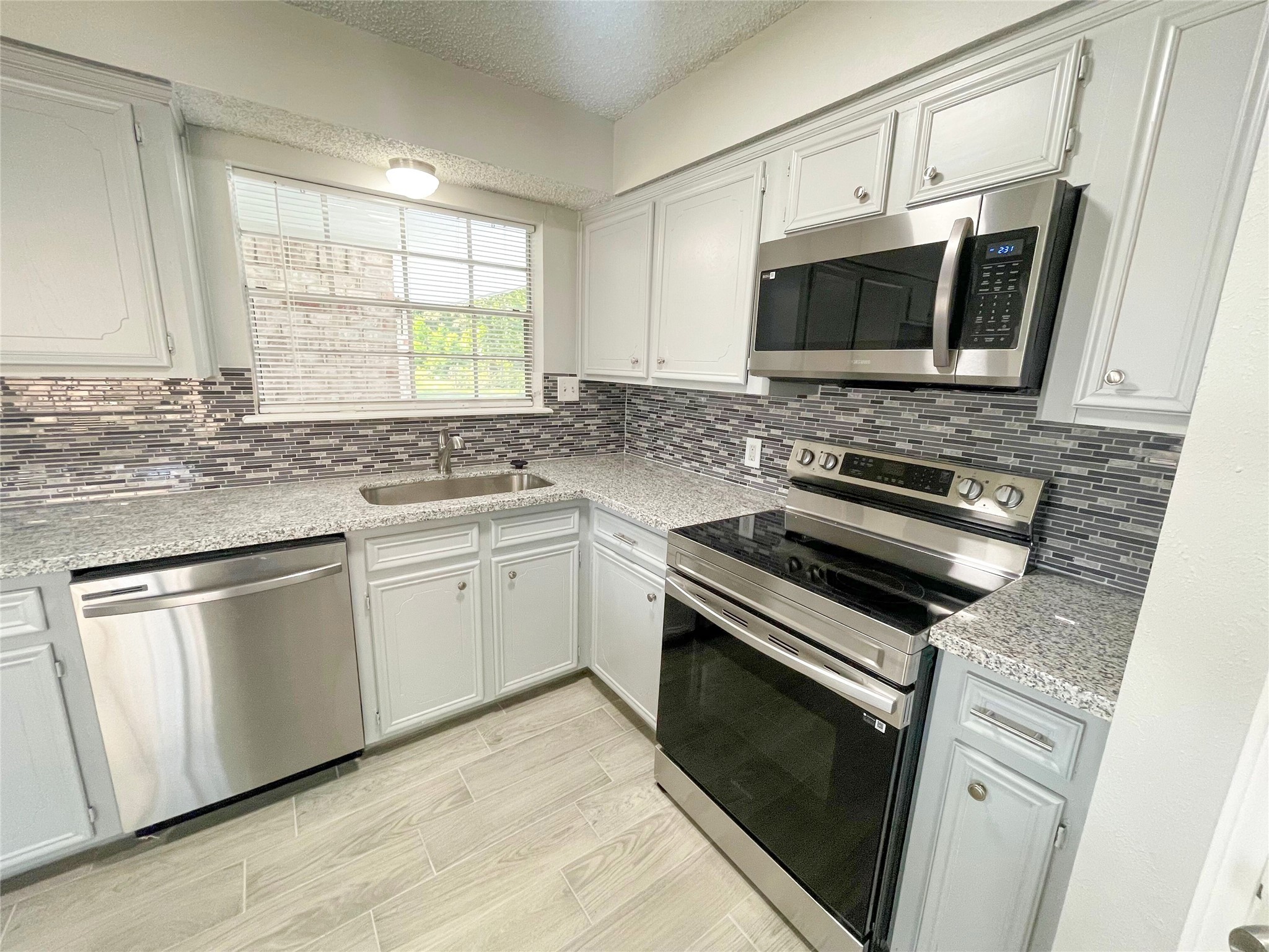 23460 Smith Road Porter, TX 77365 - Photo 18 of 46 a kitchen with stainless steel appliances a stove microwave and sink