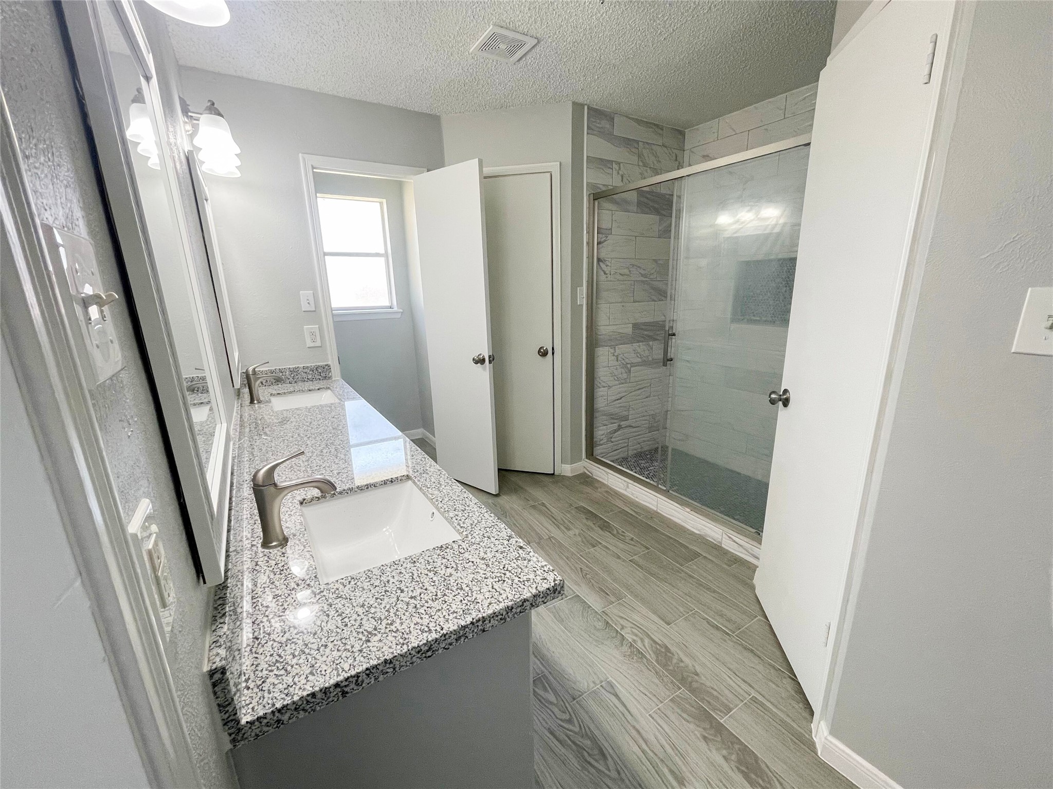 23460 Smith Road Porter, TX 77365 - Photo 29 of 46 a bathroom with a granite countertop sink a mirror and shower
