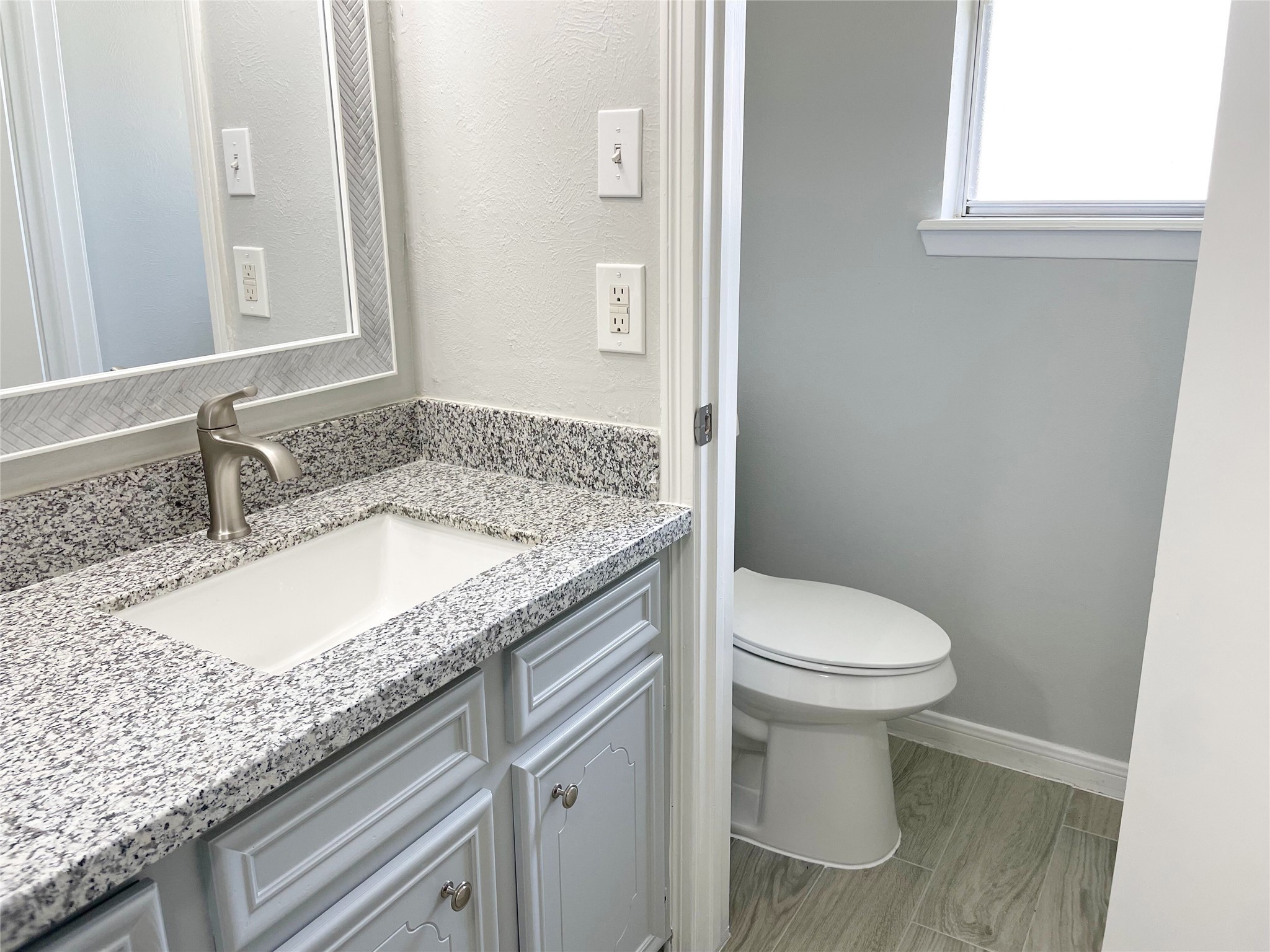 23460 Smith Road Porter, TX 77365 - Photo 32 of 46 a bathroom with a granite countertop sink a toilet and a mirror