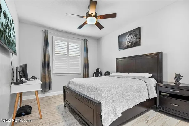 a bedroom with a bed flat screen tv and a window