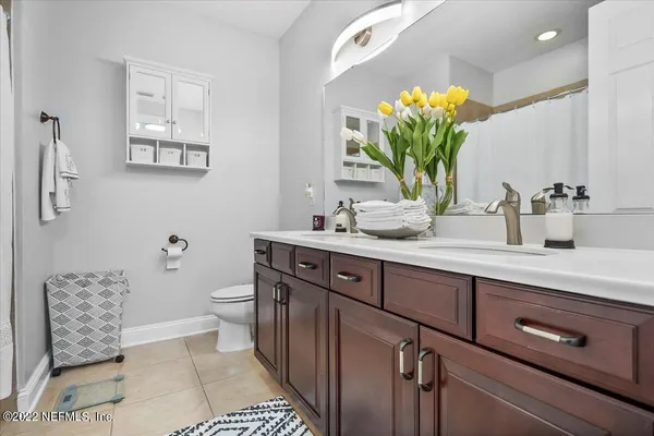 a bathroom with a sink a mirror and a potted plant