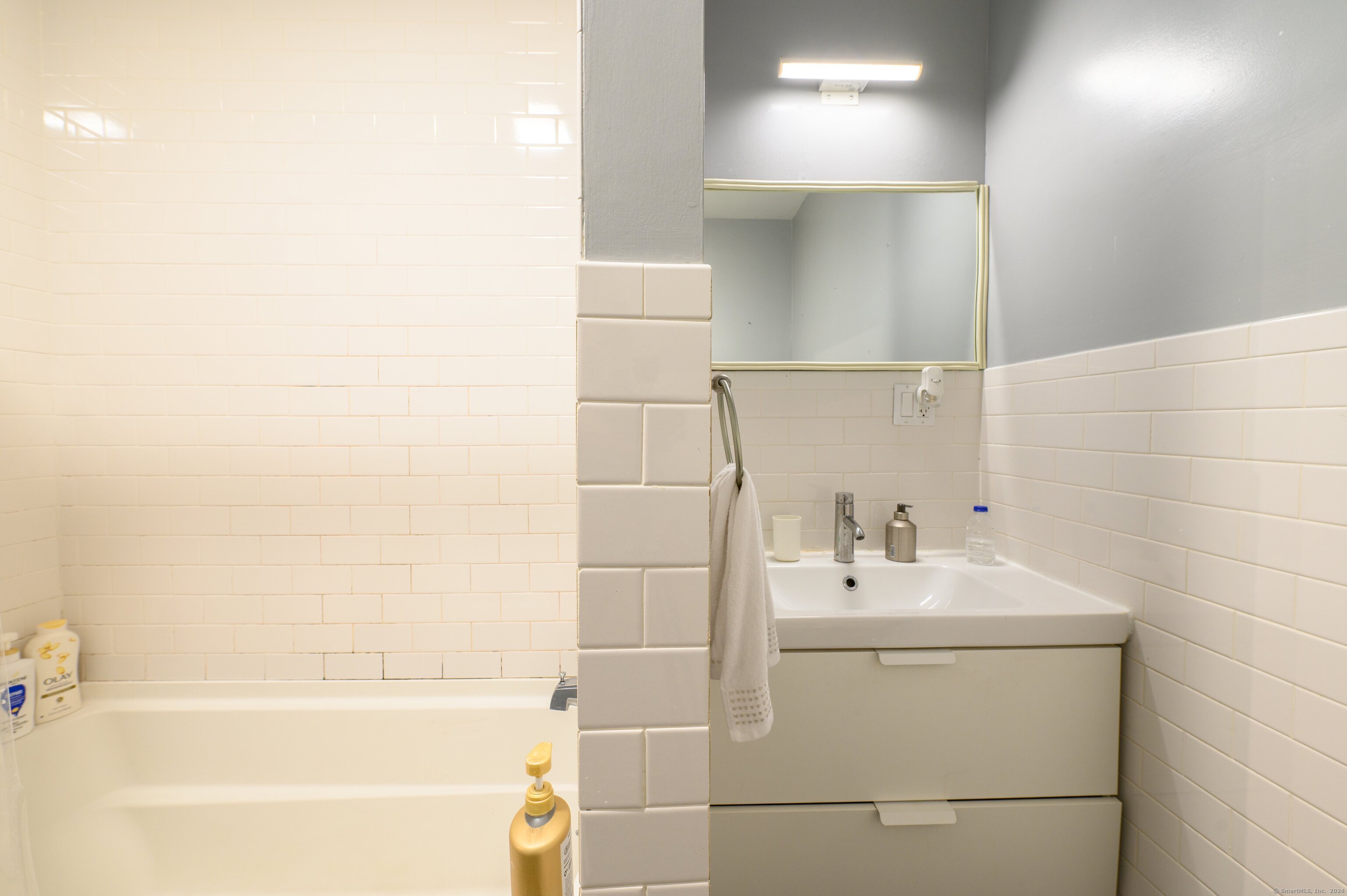 54 Mechanic Street New Haven, CT 06511 - Photo 16 of 22 a bathroom with a sink a mirror and a bathtub