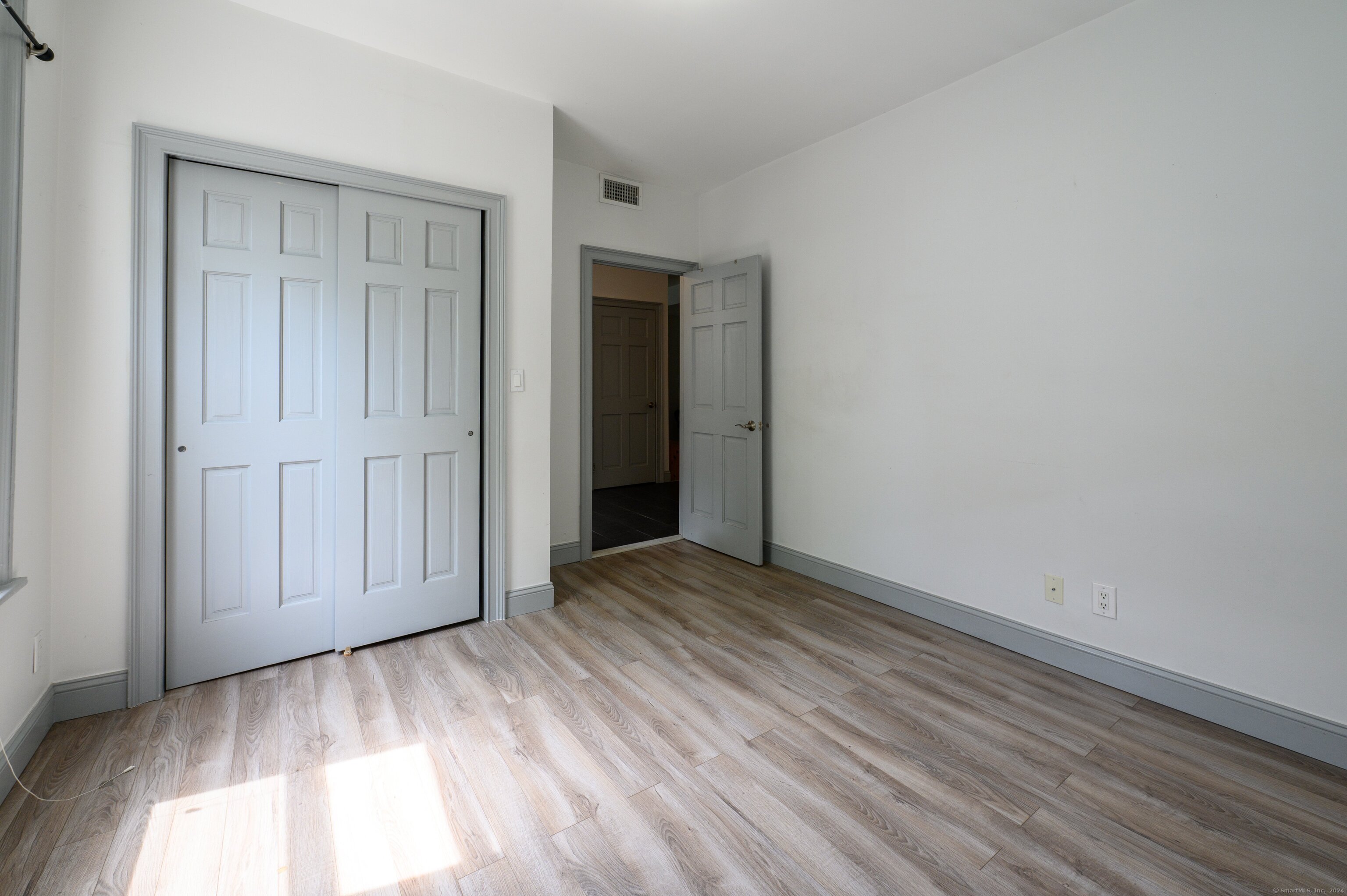 54 Mechanic Street New Haven, CT 06511 - Photo 7 of 22 a view of an empty room with closet and wooden floor