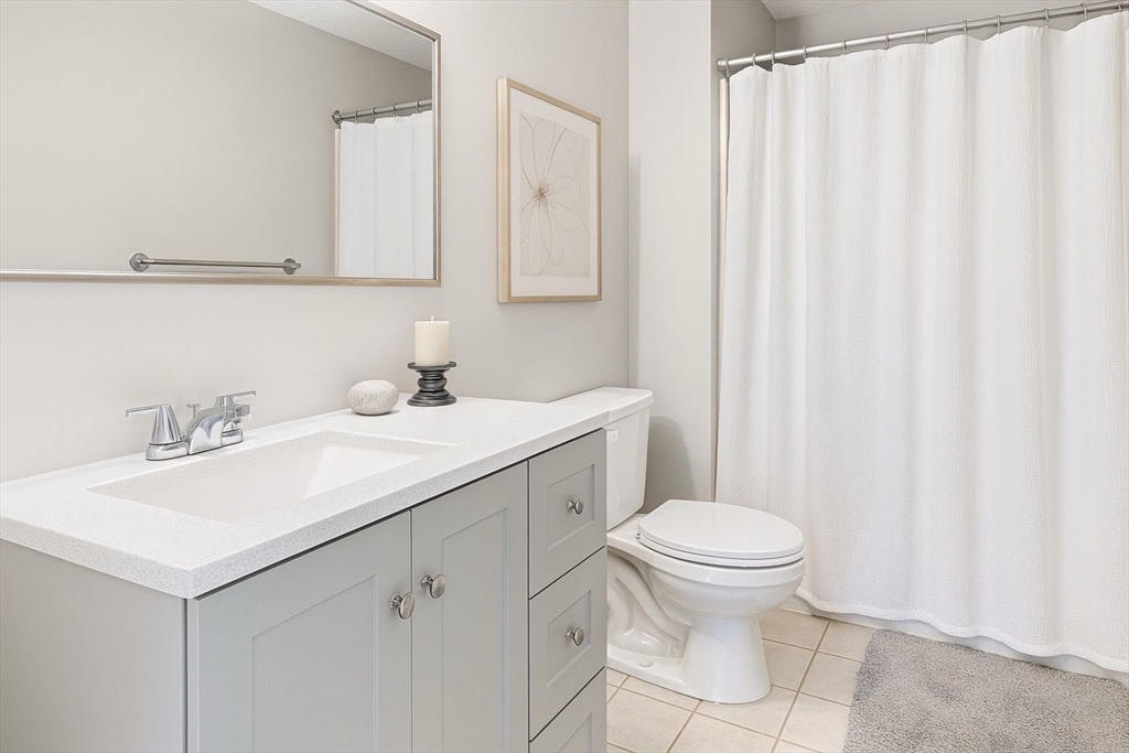8 9th Street, Unit 511 Medford, MA 02155 - Photo 6 of 12 a bathroom with a toilet sink and mirror