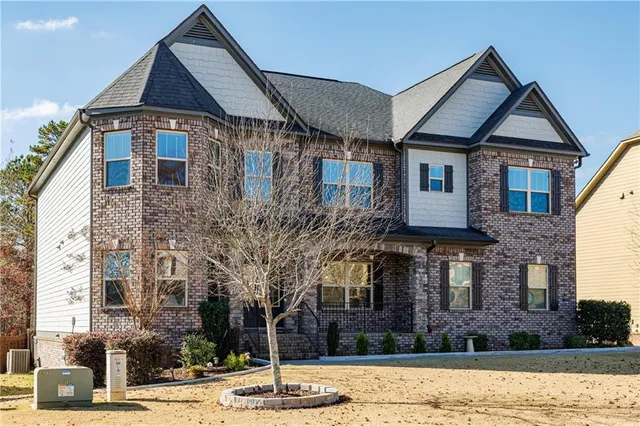 a view of an empty room with wooden floor and a chandelier