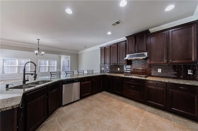 a view of an empty room with wooden floor and a ceiling fan