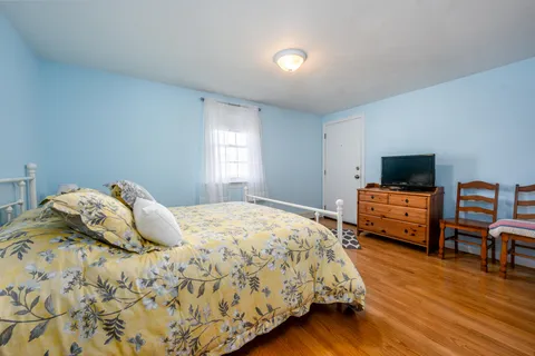 a bedroom with a bed and wooden floor