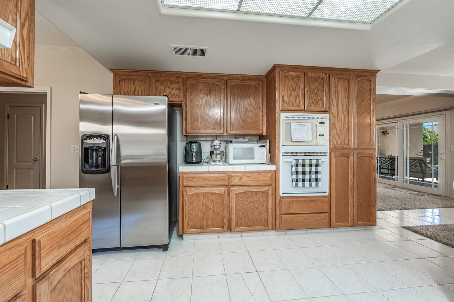 3432 Doubletree Way Madera, CA 93637 - Photo 11 of 45 a kitchen with granite countertop a refrigerator and a sink