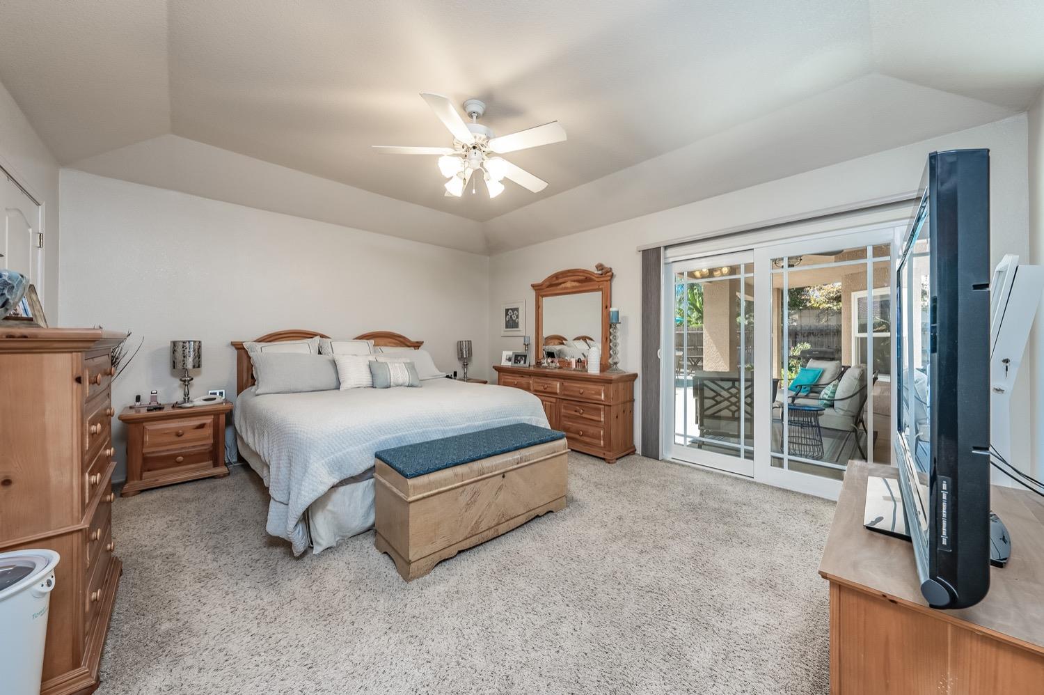 3432 Doubletree Way Madera, CA 93637 - Photo 17 of 45 a spacious bedroom with a bed and a chandelier