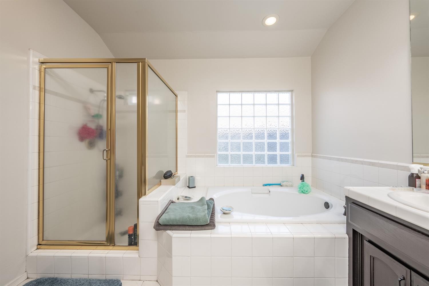 3432 Doubletree Way Madera, CA 93637 - Photo 20 of 45 a bathroom with a tub sink and mirror