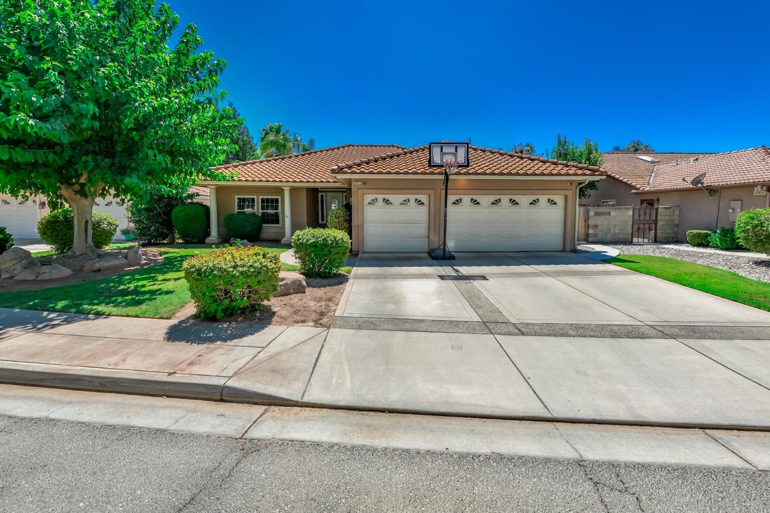 3432 Doubletree Way Madera, CA 93637 - Photo 28 of 45 a front view of a house with a yard and garage