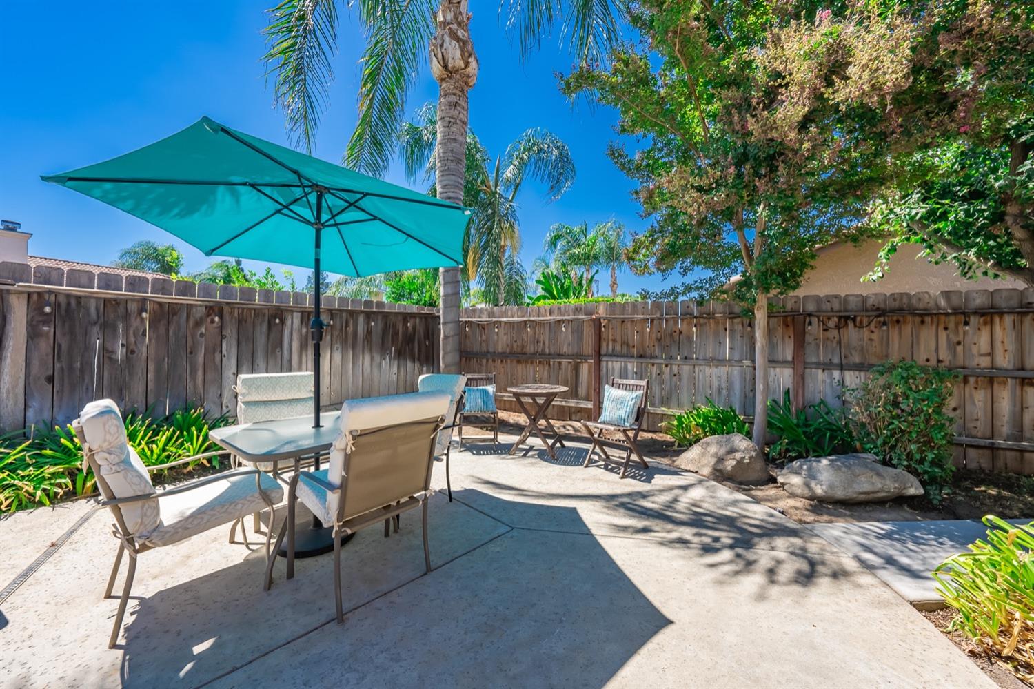 3432 Doubletree Way Madera, CA 93637 - Photo 32 of 45 a view of a patio with a table and chairs under an umbrella