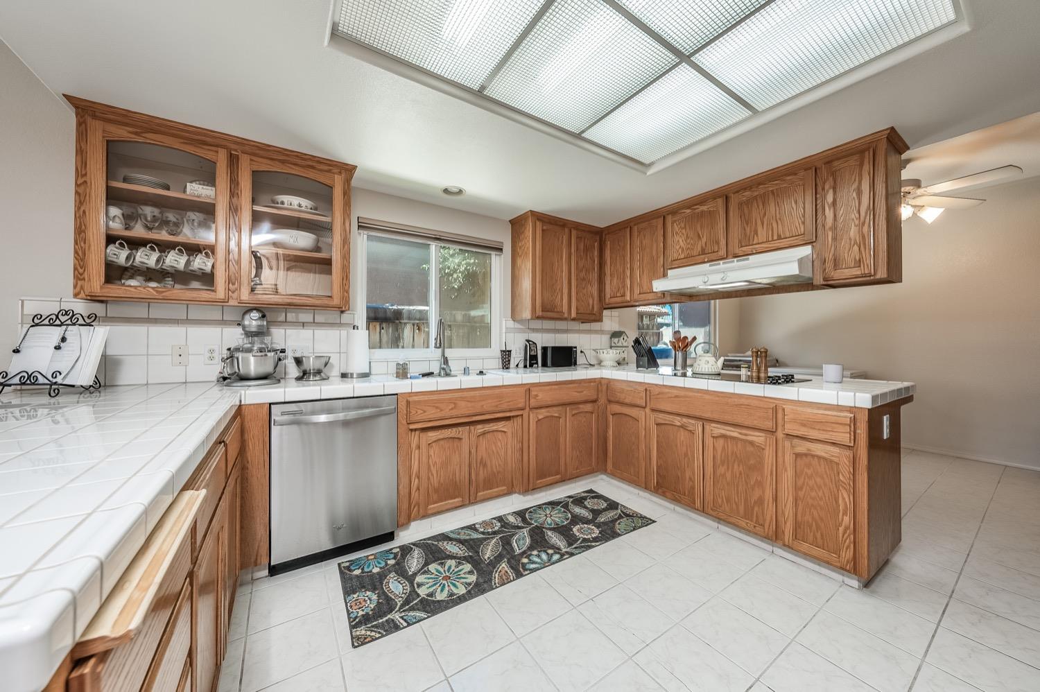 3432 Doubletree Way Madera, CA 93637 - Photo 9 of 45 a kitchen with stainless steel appliances kitchen island granite countertop a sink stove and cabinets