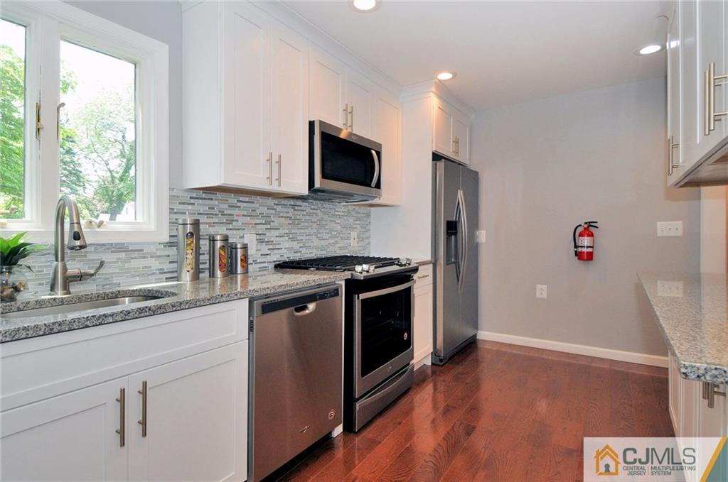 29 Stockton Road New Brunswick, NJ 08901 - Photo 8 of 21 a kitchen with stainless steel appliances granite countertop a stove a sink and a microwave