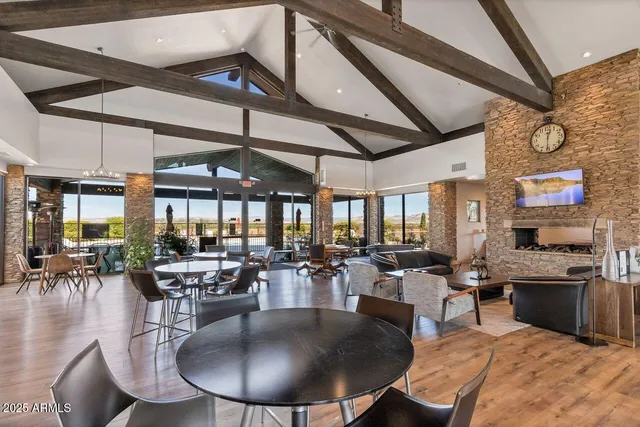 a living room with furniture a large window and wooden floor