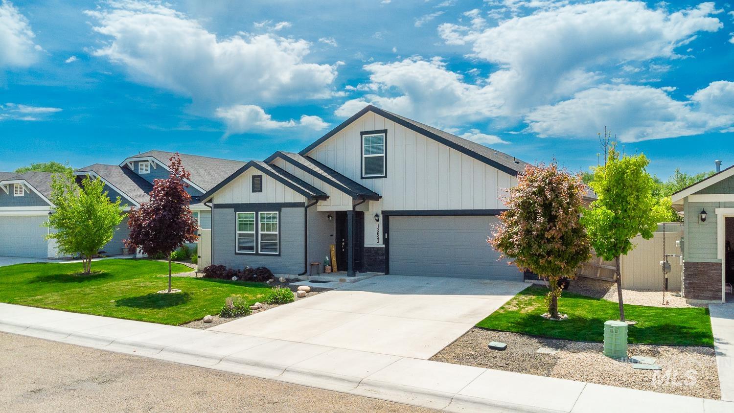12623 Shadow Peak Street Caldwell, ID 83607 - Photo 2 of 50 Contemporary exterior with mixed siding, featuring a two-car garage, concrete driveway, and manicured landscaping