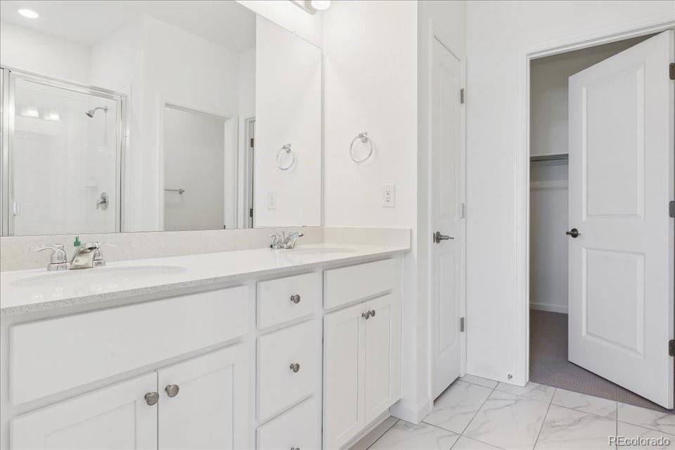 6800 Merseyside Lane, Unit 166 Castle Pines, CO 80108 - Photo 11 of 21 a bathroom with double sink and a mirror