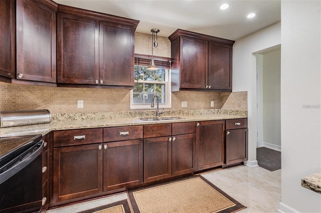 701 Poinsettia Road, Unit 248 Belleair, FL 33756 - Photo 14 of 38 a kitchen with granite countertop wooden cabinets and a stainless steel appliances