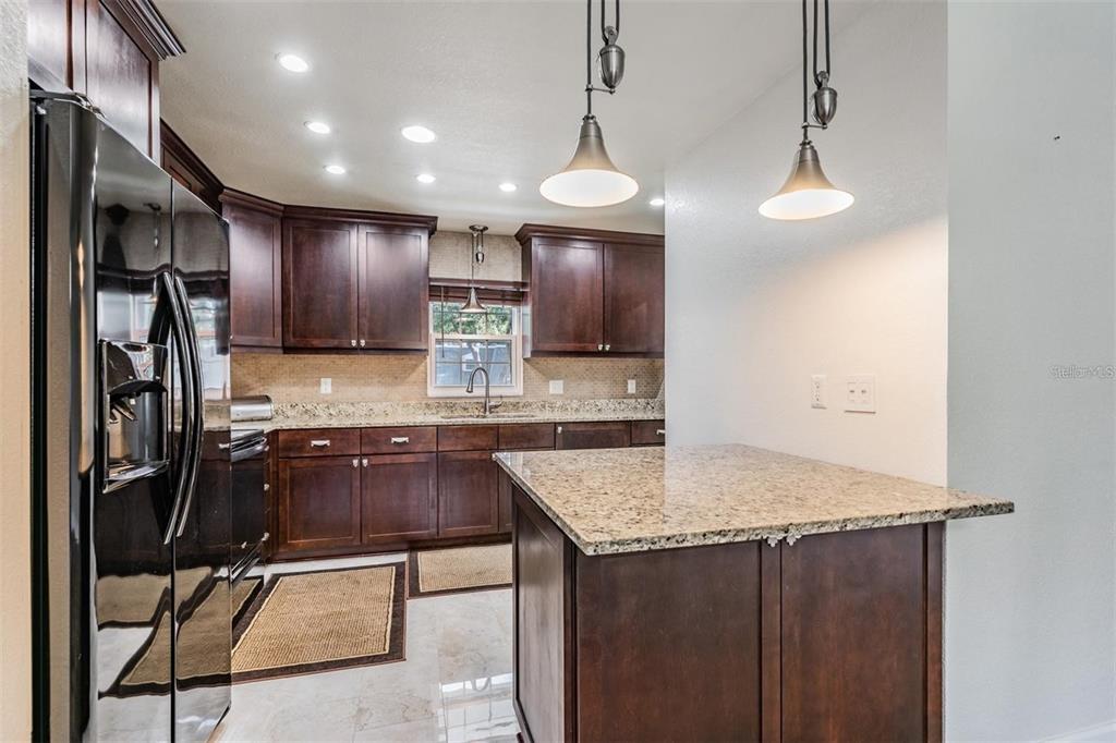 701 Poinsettia Road, Unit 248 Belleair, FL 33756 - Photo 15 of 38 a kitchen with stainless steel appliances granite countertop a refrigerator a sink and a stove