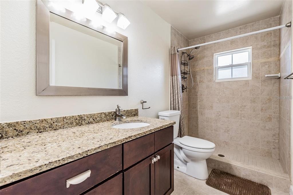 701 Poinsettia Road, Unit 248 Belleair, FL 33756 - Photo 19 of 38 a bathroom with a granite countertop sink mirror vanity and toilet
