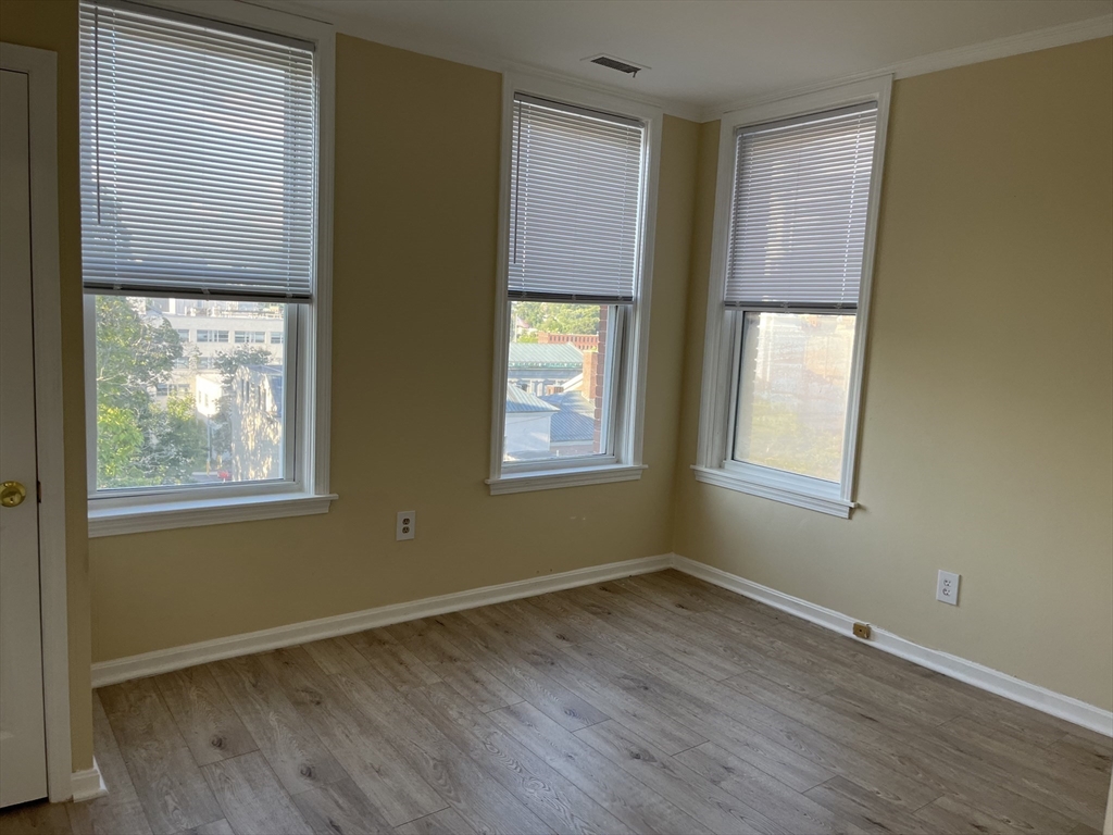 5 State Street, Unit 4F Worcester, MA 01609 - Photo 4 of 9 a view of an empty room with wooden floor and a window