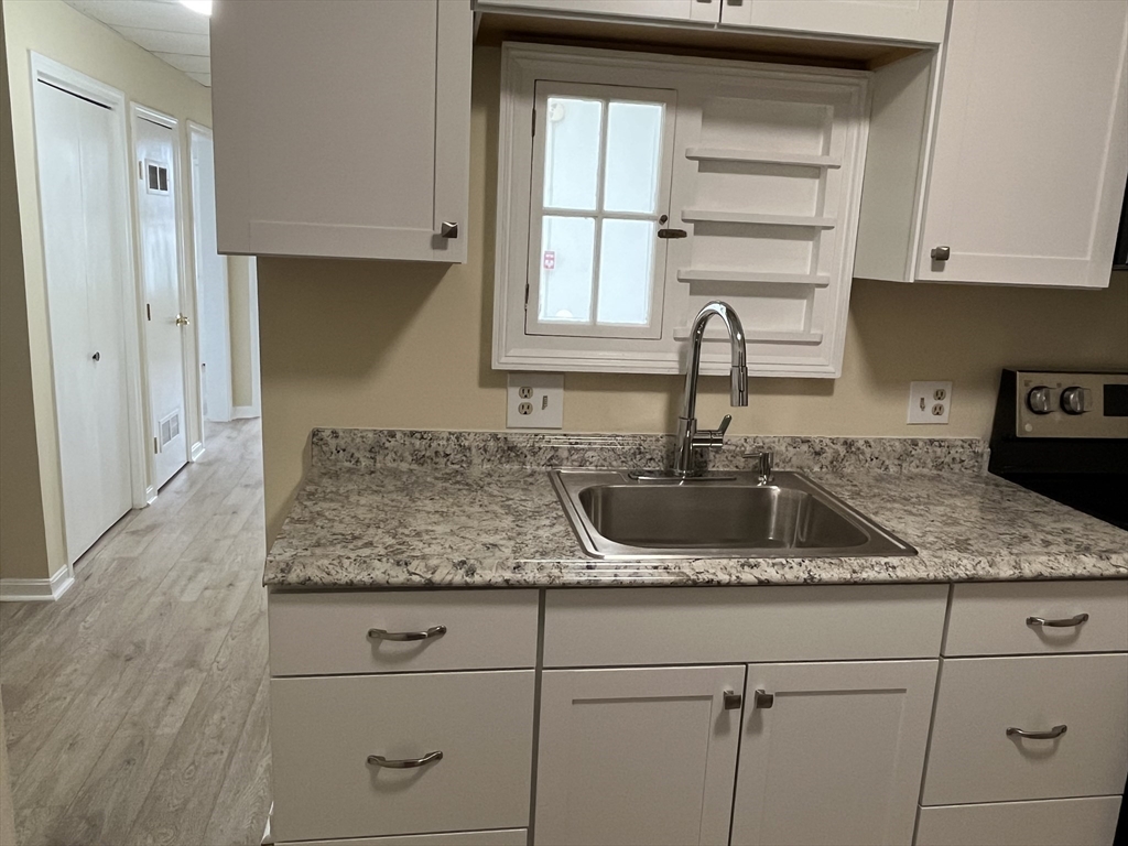 5 State Street, Unit 4F Worcester, MA 01609 - Photo 5 of 9 a kitchen with granite countertop a sink and a window