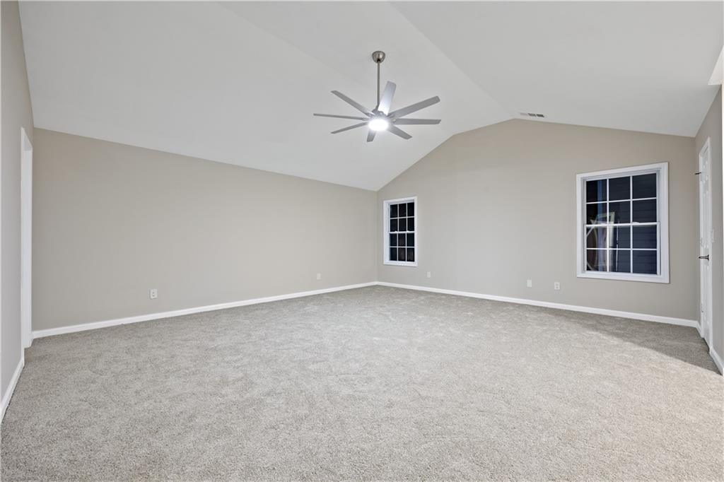 1549 Stewart Ridge Drive Buford, GA 30518 - Photo 13 of 32 an empty room with windows and ceiling fan