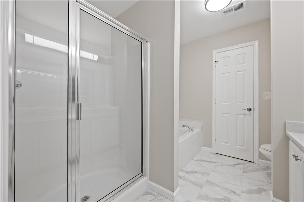 1549 Stewart Ridge Drive Buford, GA 30518 - Photo 17 of 32 a bathroom with a shower and a glass door