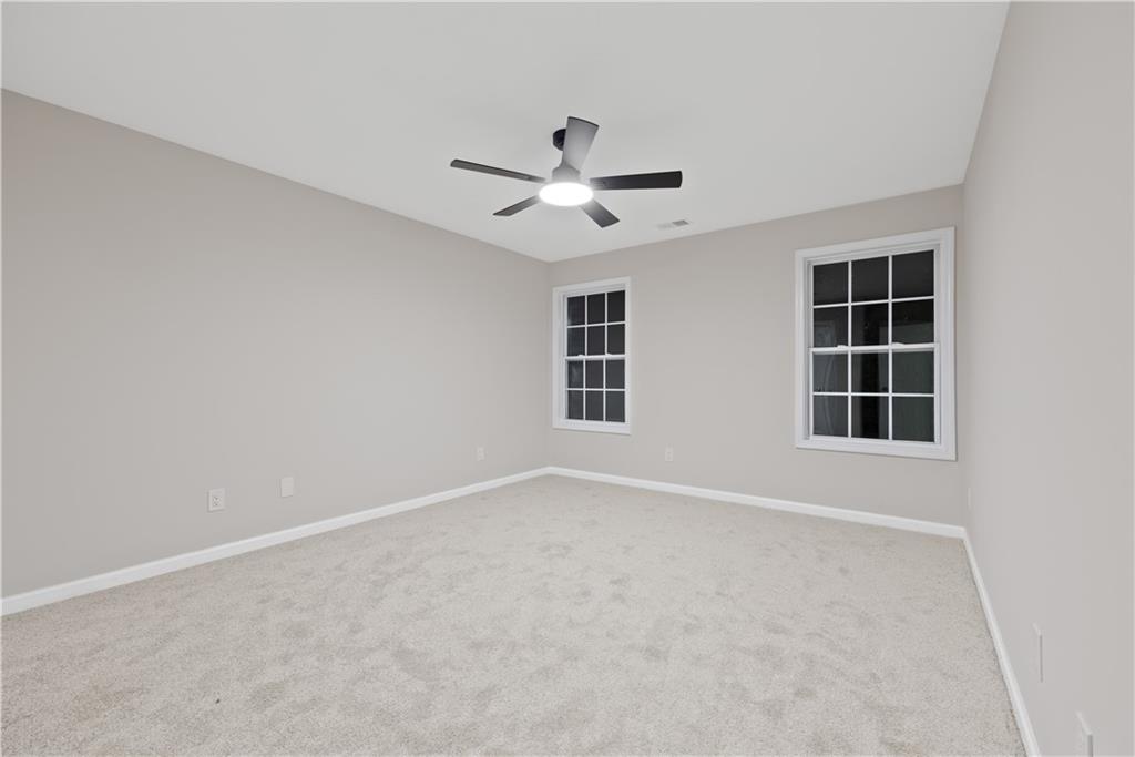 1549 Stewart Ridge Drive Buford, GA 30518 - Photo 19 of 32 an empty room with windows and fan