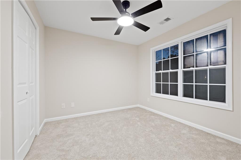1549 Stewart Ridge Drive Buford, GA 30518 - Photo 22 of 32 an empty room with a window and a ceiling fan