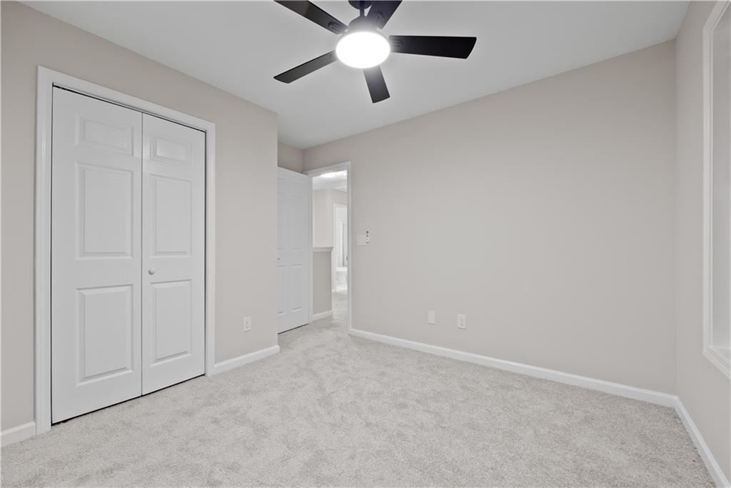 1549 Stewart Ridge Drive Buford, GA 30518 - Photo 25 of 32 an empty room with closet and a chandelier fan