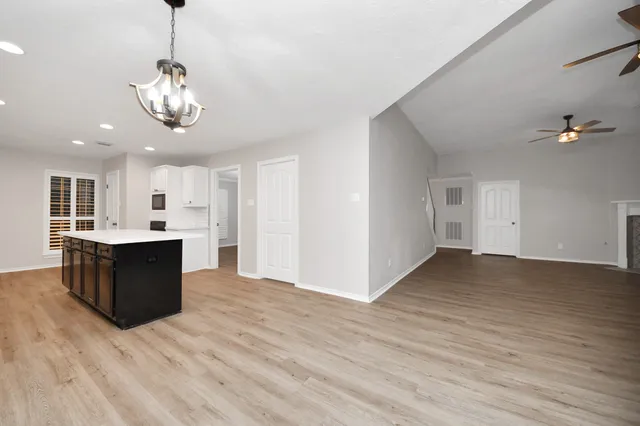 a view of a kitchen with a sink and dishwasher with wooden floor
