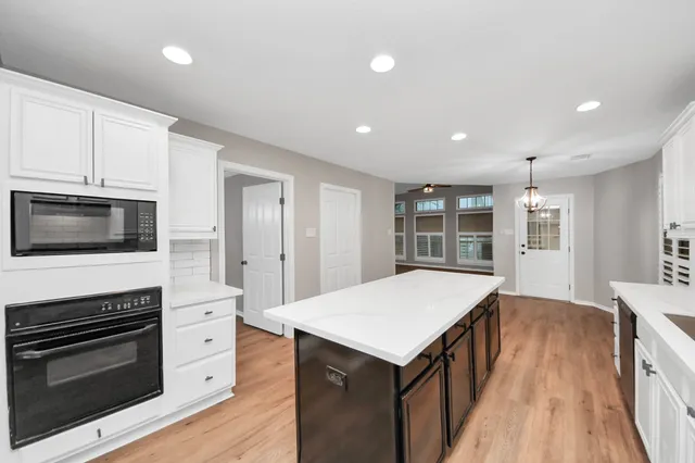 an empty room with windows and fan