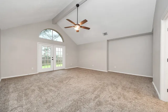 an empty room with a ceiling fan and a window